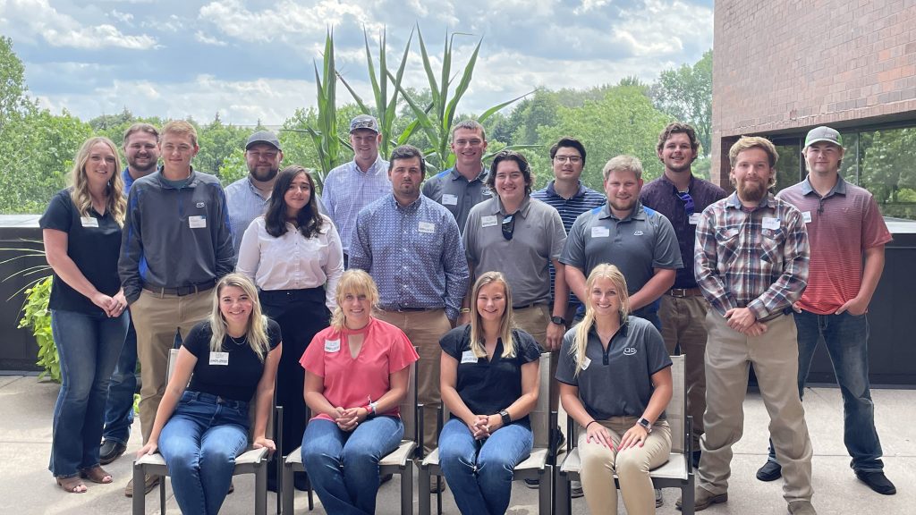 Group of interns standing and sitting on an outdoor patio