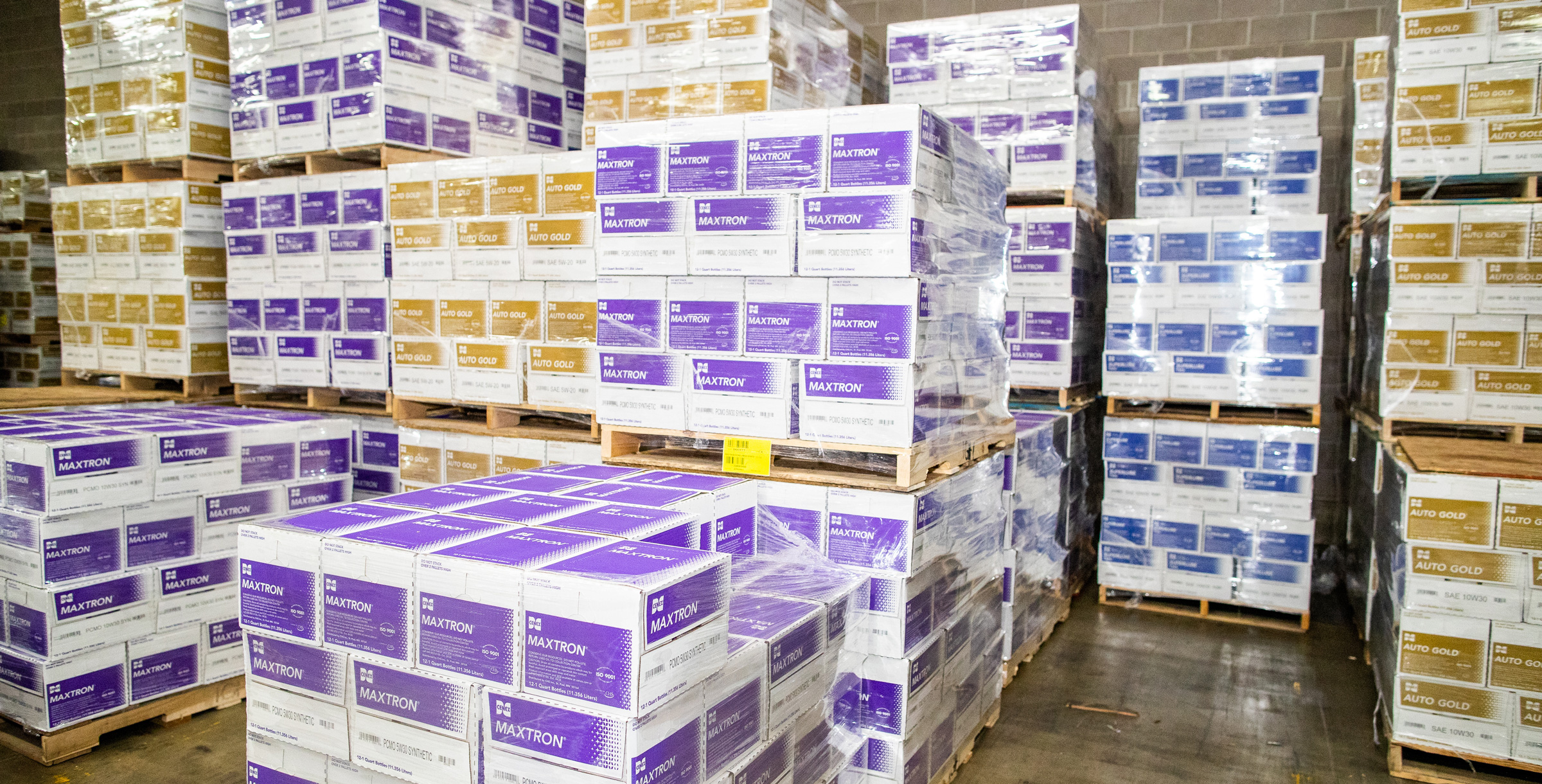 Cenex Maxtron and Autogold product boxes sitting on pallets in a warehouse